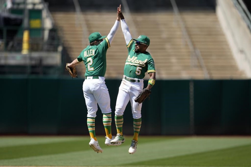 Oakland Athletics' Nick Allen (2) celebrates with Tony Kemp (5) after the Athletics defeated the Boston Red Sox in a baseball game in Oakland, Calif., Wednesday, July 19, 2023. (AP Photo/Jeff Chiu)