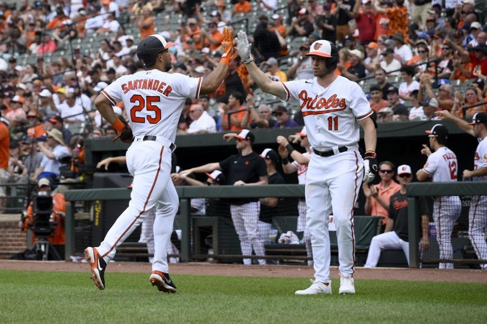 Baltimore Orioles' Anthony Santander (25) gets a high-five from Jordan Westburg (11) after scoring on a single by Aaron Hicks during the first inning of a baseball game against the Los Angeles Dodgers, Wednesday, July 19, 2023, in Baltimore. (AP Photo/Nick Wass)