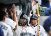 Seattle Mariners' Eugenio Suarez, center, has sunflower seeds tosses at his face in the dugout after his two-run home run against the Minnesota Twins during the seventh inning of a baseball game Wednesday, July 19, 2023, in Seattle. (AP Photo/Lindsey Wasson)