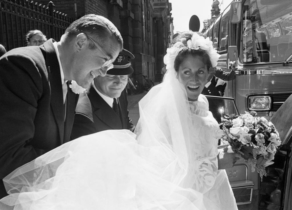 FILE - Peter O'Malley, president of the Los Angeles Dodgers, helps his bride, Annette Zacho, into a car following their wedding in Copenhagen, Denmark, July 10, 1971. Annette O’Malley, who helped her husband promote baseball globally during his family’s ownership of the Dodgers, has died Wednesday, July 19, 2023, in Los Angeles, the Dodgers announced Thursday. She was 81. (AP Photo, File)