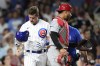 Chicago Cubs' Patrick Wisdom looks at his helmet after being struck on the helmet by a pitch from St. Louis Cardinals' Kyle Leahy, as catcher Willson Contreras stands nearby during the seventh inning of a baseball game Thursday, July 20, 2023, in Chicago. (AP Photo/Charles Rex Arbogast)