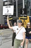 Actor/writer Tina Fey carries a sign outside Amazon and HBO studios on Tuesday, July 18, 2023, in New York. The actors strike comes more than two months after screenwriters began striking in their bid to get better pay and working conditions and have clear guidelines around the use of AI in film and television productions. (Photo by Evan Agostini/Invision/AP)