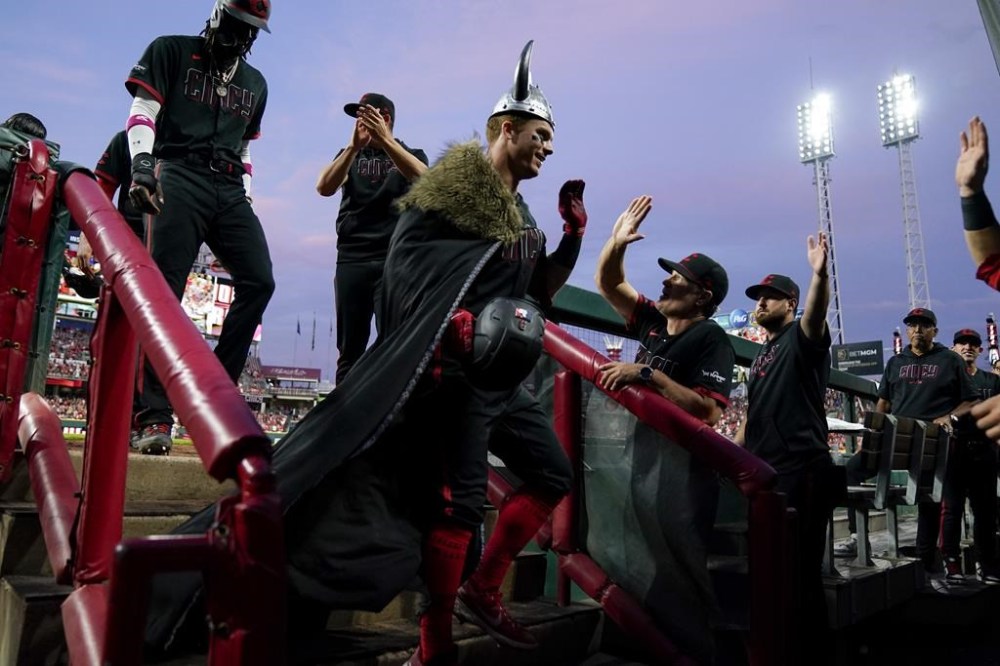Cincinnati Reds' Matt McLain, center, celebrates with teammates after hitting a grand slam during the fifth inning of a baseball game against the Arizona Diamondbacks, Friday, July 21, 2023, in Cincinnati. (AP Photo/Jeff Dean)
