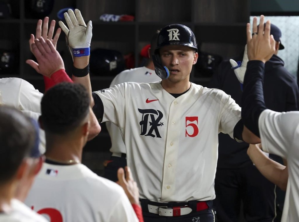 Texas Rangers' Corey Seager (5) is celebrated in the dugout after a solo home run against the Los Angeles Dodgers in the sixth inning during a baseball game, Friday, July 21, 2023, in Arlington, Texas. (AP Photo/Richard W. Rodriguez)