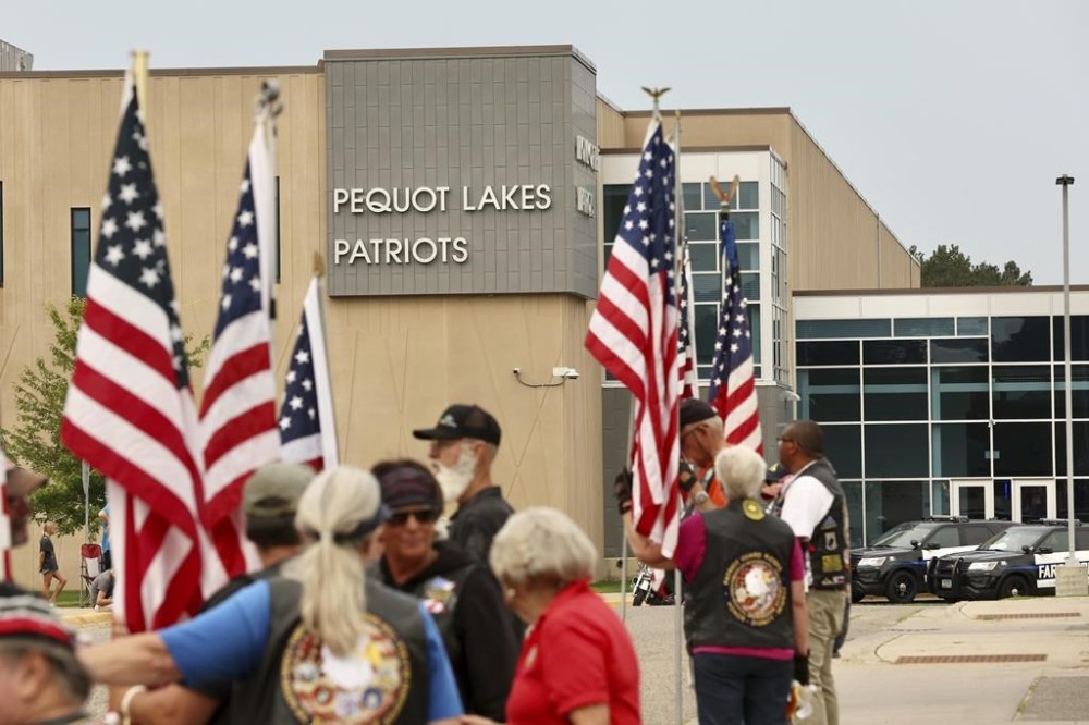 People stand outside during funeral services for Fargo Officer Jake Wallin at Pequot Lakes High School in Pequot Lakes, Minn., on Saturday, July 22, 2023. Wallin, 23, was killed July 14 when a man armed with 1,800 rounds of ammunition, multiple guns and explosives began firing. (Paul Middlestaedt/Minnesota Public Radio via AP)