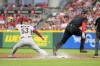 Cincinnati Reds' Tyler Stephenson (37) reaches first base against Arizona Diamondbacks first baseman Christian Walker (53) during the fifth inning of a baseball game Friday, July 21, 2023, in Cincinnati. (AP Photo/Jeff Dean)