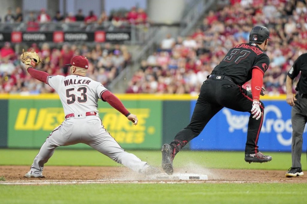 Cincinnati Reds' Tyler Stephenson (37) reaches first base against Arizona Diamondbacks first baseman Christian Walker (53) during the fifth inning of a baseball game Friday, July 21, 2023, in Cincinnati. (AP Photo/Jeff Dean)