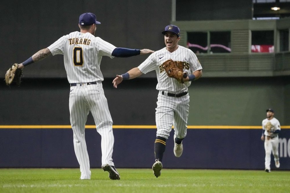 Milwaukee Brewers' Sal Frelick is congratulated by Brice Turang after making two catches at the wall during the sixth inning of a baseball game against the Atlanta Braves Saturday, July 22, 2023, in Milwaukee. (AP Photo/Morry Gash)