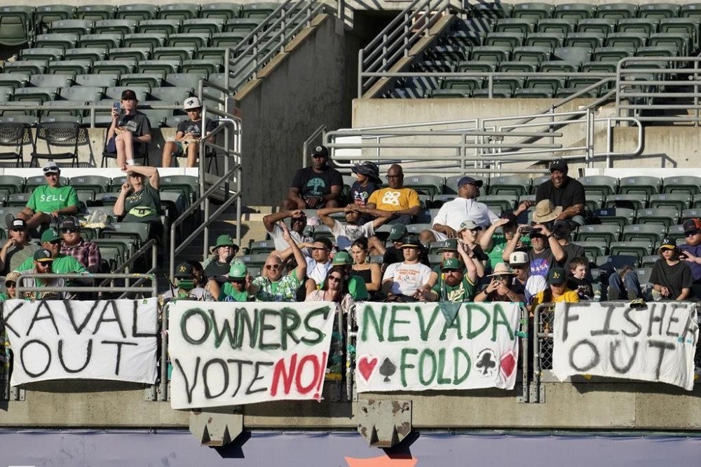 Fans sit behind signs hanging in right field at Oakland Alameda Coliseum during a baseball game between the Oakland Athletics and the Houston Astros in Oakland, Calif., Saturday, July 22, 2023. (AP Photo/Jeff Chiu)