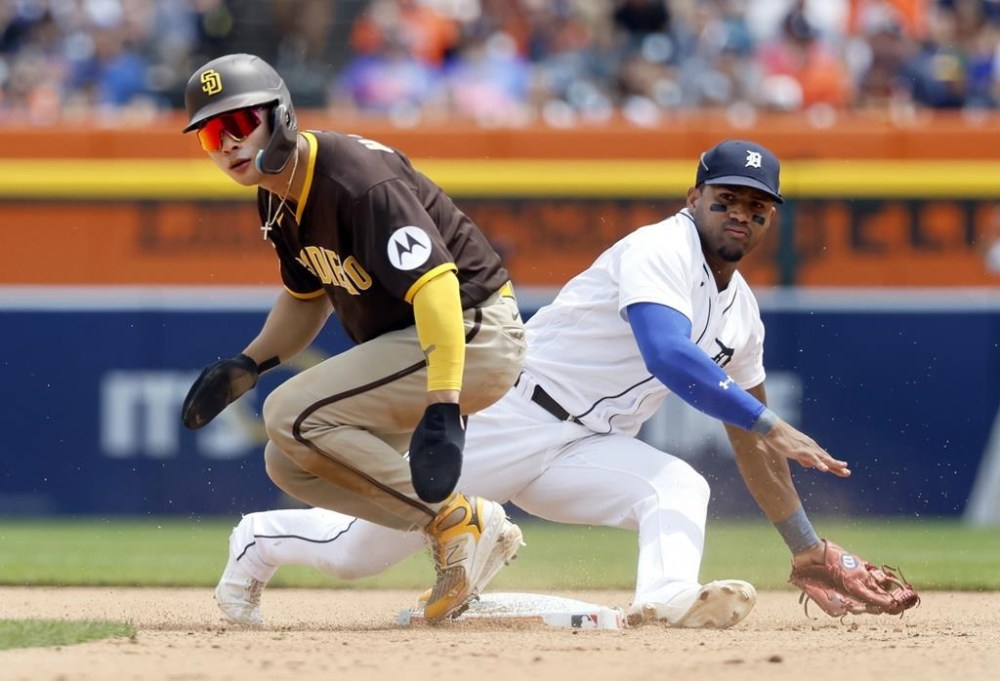 San Diego Padres' Ha-Seong Kim, left, and Detroit Tigers second baseman Andy Ibanez, right, watch a throw to first base that completes a double play against Padres' Fernando Tatis Jr. during the fifth inning of a baseball game Sunday, July 23, 2023, in Detroit. (AP Photo/Duane Burleson)
