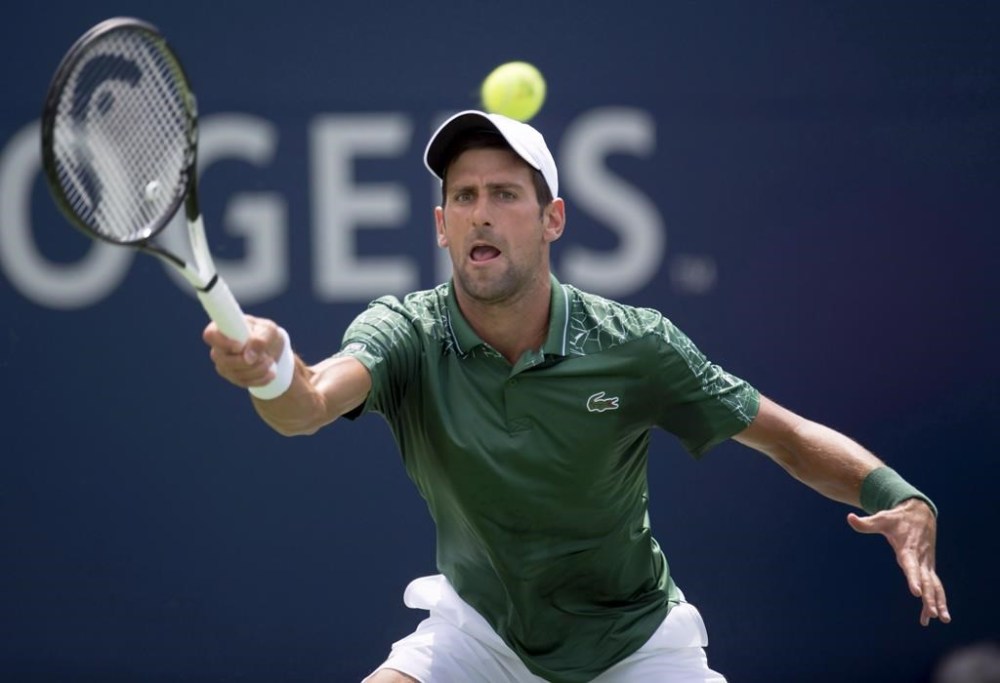 Novak Djokovic, of Serbia, makes a return to Stefanos Tsitsipas, of Greece, during Rogers Cup tennis tournament action in Toronto on Thursday August 9, 2018. THE CANADIAN PRESS/Frank Gunn
