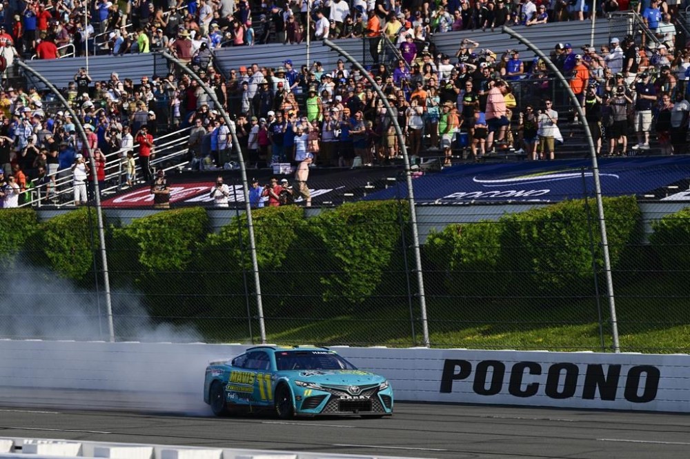 Denny Hamlin celebrates with a burnout after winning a NASCAR Cup Series auto race at Pocono Raceway, Sunday, July 23, 2023, in Long Pond, Pa. (AP Photo/Derik Hamilton)