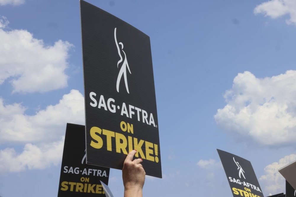 Striking screenwriters and actors hold signs at a rally in Chicago, Thursday, July 20, 2023, as the labour dispute that has halted Hollywood spreads to more cities. Twin Hollywood strikes that stalled U.S. film and TV production could raise demand for Canadian talent if the job action stretches beyond the summer. THE CANADIAN PRESS/AP/Teresa Crawford