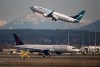 Figures from an aviation data firm show Canada's two biggest airlines see a far higher proportion of their flights delayed compared with many of their peers abroad. An Air Canada flight taxis to a runway as a WestJet flight takes off at Vancouver International Airport, in Richmond, B.C., on March 20, 2020. THE CANADIAN PRESS/Darryl Dyck