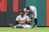 Baltimore Orioles center fielder Aaron Hicks, left, grabs his hand after catching the line-out by Philadelphia Phillies' Johan Rojas as Austin Hays, right, tries to help him up during the third inning of a baseball game, Monday, July 24, 2023, in Philadelphia. (AP Photo/Chris Szagola)