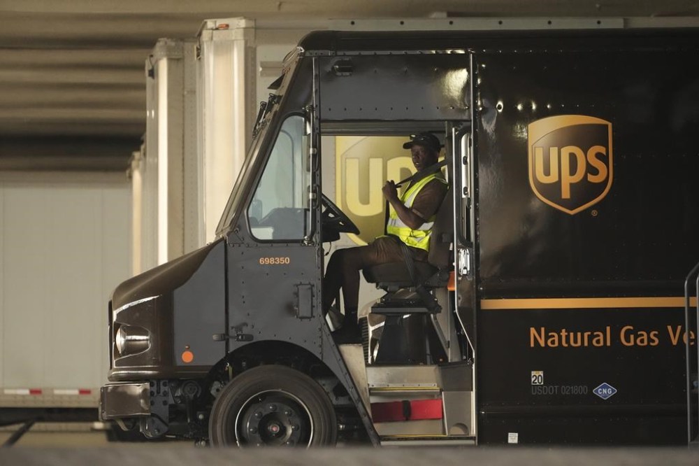 FILE - A UPS driver puts his seat belt on before driving off as UPS workers hold a rally in downtown Los Angeles as a national strike deadline nears on Wednesday, July 19, 2023. UPS has reached a contract agreement with its 340,000-person strong union Tuesday, July 25, 2023, averting a strike that had the potential to disrupt logistics nationwide for businesses and households alike. (AP Photo/Damian Dovarganes, File)