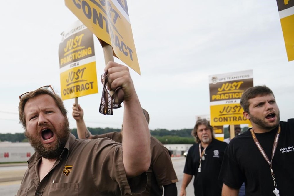 FILE - UPS teamsters and workers hold a rally, Friday, July 21, 2023, in Atlanta, as a national strike deadline nears. UPS has reached a contract agreement with its 340,000-person strong union Tuesday, July 25, 2023, averting a strike that had the potential to disrupt logistics nationwide for businesses and households alike. (AP Photo/Brynn Anderson, File)