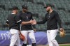 Chicago White Sox manager Pedro Grifol, left, shakes hands with Yoán Moncada as Oscar Colas watches, during infield practice before the team's baseball game against the Chicago Cubs, Tuesday, July 25, 2023, in Chicago. Moncada returned to the team after an injury rehabilitation assignment, reinstating him from the 10-day injured list. (AP Photo/Charles Rex Arbogast)