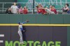 Fans reach for a home run ball hit by Cleveland Guardians' Bo Naylor behind Kansas City Royals center fielder Kyle Isbel in the fifth inning of a baseball game Tuesday, July 25, 2023, in Cleveland. (AP Photo/Sue Ogrocki)