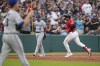 Cleveland Guardians' Bo Naylor, right, runs past Kansas City Royals starting pitcher Zack Greinke, left, and second baseman Nicky Lopez (8) as he rounds the bases after hitting a home run in the fifth inning of a baseball game Tuesday, July 25, 2023, in Cleveland. (AP Photo/Sue Ogrocki)