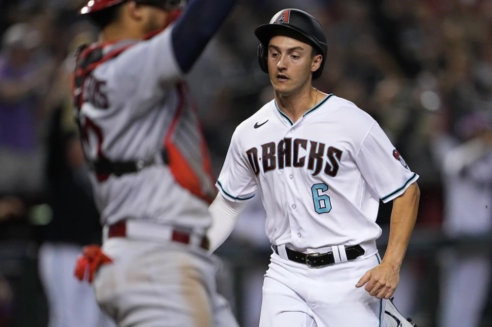 Arizona Diamondbacks' Dominic Canzone scores on a triple hit by Corbin Carroll during the eighth inning of a baseball game against the St. Louis Cardinals, Tuesday, July 25, 2023, in Phoenix. (AP Photo/Matt York)
