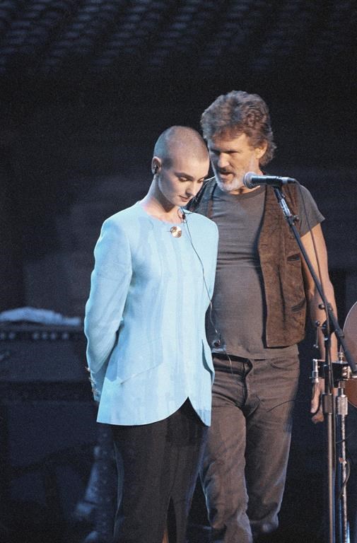 FILE - Kris Kristofferson comforts Sinead O'Connor after she was booed off stage during the Bob Dylan anniversary concert at New York Madison Square Garden, on Oct. 17, 1992. The performance was O'Connor's first live event since she ripped a picture of Pope John Paul II during a performance on
