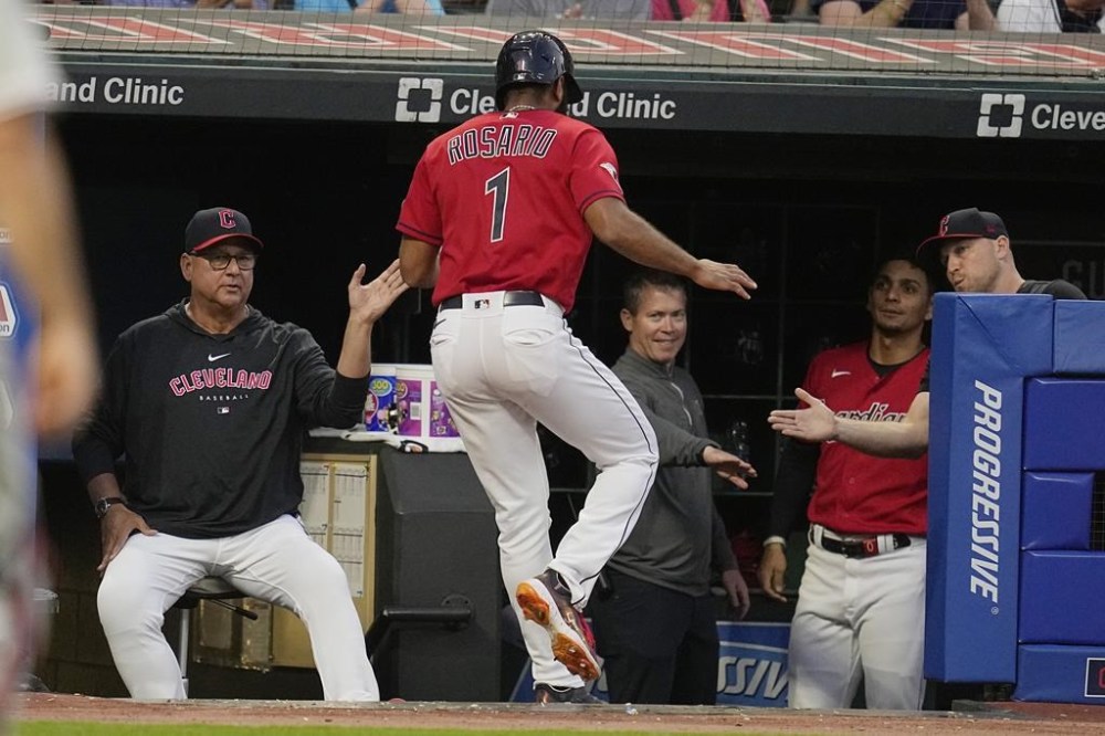 Cleveland Guardians' Amed Rosario is greeted as he returns to the dugout after scoring on a single hit by Jose Ramirez in the sixth inning of a baseball game Saturday, July 22, 2023, in Cleveland. (AP Photo/Sue Ogrocki)