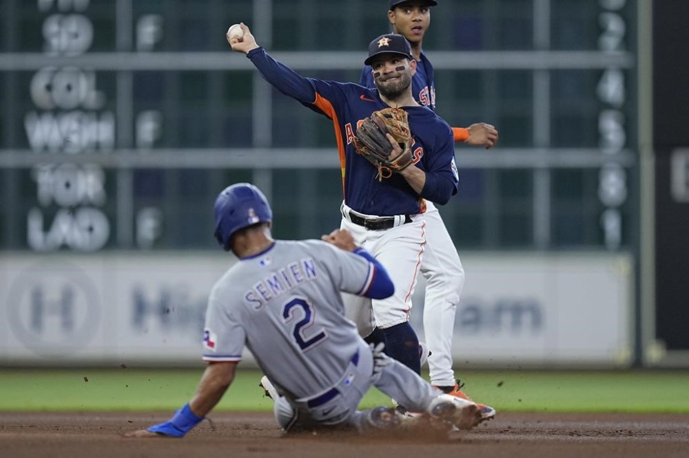 Houston Astros second baseman Jose Altuve forces out Texas Rangers' Marcus Semien and turns a double play on Ezequiel Duran during the first inning of a baseball game, Wednesday, July 26, 2023, in Houston. (AP Photo/Kevin M. Cox)