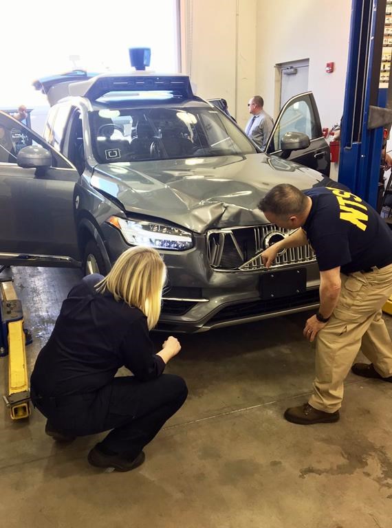 FILE - In this photo provided by the National Transportation Safety Board, investigators examine a driverless Uber SUV, March 20, 2018, that fatally struck a woman in Tempe, Ariz. Rafaela Vasquez, the backup Uber driver involved in the first death involving a fully autonomous vehicle, has pleaded guilty to endangerment. (National Transportation Safety Board via AP, File)