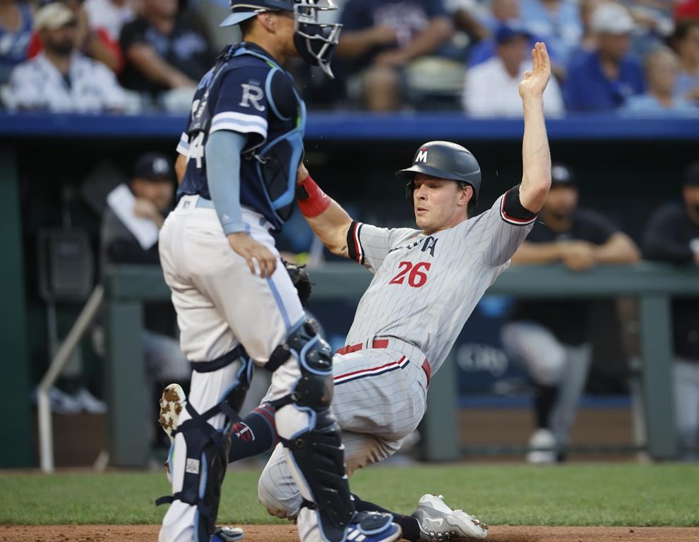 Minnesota Twins' Max Kepler (26) slides past Kansas City Royals catcher Freddy Fermin to score during the fourth inning of a baseball game in Kansas City, Mo., Friday, July 28, 2023. (AP Photo/Colin E. Braley)