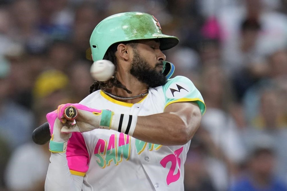 San Diego Padres' Fernando Tatis Jr. moves away from a high and inside pitch while batting during the third inning of a baseball game against the Texas Rangers, Friday, July 28, 2023, in San Diego. (AP Photo/Gregory Bull)
