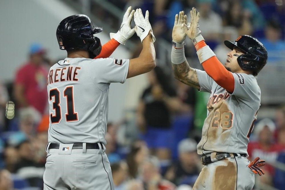 Detroit Tigers' Riley Greene (31) and Javier Baez (28) celebrate after scoring during the third inning of a baseball game against the Miami Marlins, Sunday, July 30, 2023, in Miami. (AP Photo/Marta Lavandier)