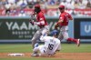 Cincinnati Reds shortstop Elly De La Cruz, left, throws to first over Los Angeles Dodgers' Will Smith (16) to turn a double play during the first inning of a baseball game in Los Angeles, Sunday, July 30, 2023. Max Muncy was out at first. (AP Photo/Ashley Landis)