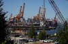 Gantry cranes sit idle as a container ship is docked at port during a work stoppage, in Vancouver, on Wednesday, July 19, 2023. THE CANADIAN PRESS/Darryl Dyck