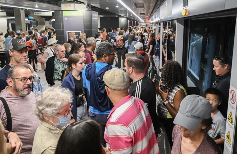 People enter and exit a Reseau express metropolitain (REM) light rail train at Central Station in Montreal, Saturday, July 29, 2023. The organization responsible for Montreal's new light-rail train line, says it's looking into the situation after track switch problems led to two service disruptions within 24 hours of the network's official launch on Monday. THE CANADIAN PRESS/Graham Hughes