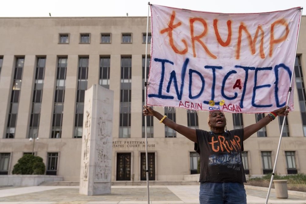 Nadine Seiler protest as she holds a banner outside federal court Tuesday, Aug. 1, 2023 in Washington. Former President Donald Trump has been charged by the Justice Department for his efforts to overturn the results of the 2020 presidential election. (AP Photo/Jose Luis Magana)