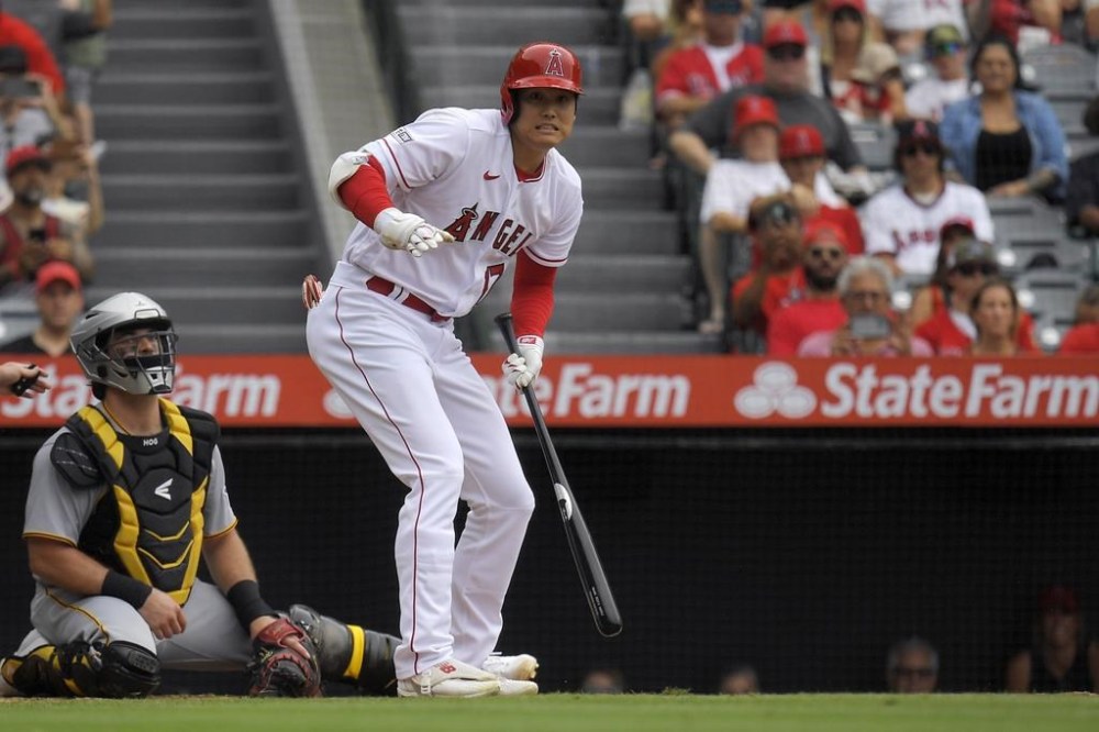 Los Angeles Angels' Shohei Ohtani, right, reacts after hitting a foul ball toward the photo well as Pittsburgh Pirates catcher Austin Hedges watches during the first inning of a baseball game, Sunday, July 23, 2023, in Anaheim, Calif. (AP Photo/Mark J. Terrill)