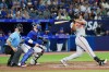 Baltimore Orioles' Anthony Santander (25) hits a grand slam as Toronto Blue Jays catcher Danny Jansen (9) looks on during eighth inning American League MLB baseball action in Toronto on Tuesday, August 1, 2023. THE CANADIAN PRESS/Nathan Denette