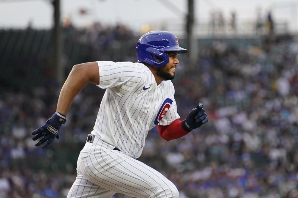 Chicago Cubs' Jeimer Candelario heads to first on his single off Cincinnati Reds starting pitcher Ben Lively, after joining the Cubs in a trade with the Washington Nationals, during the first inning of a baseball game Tuesday, Aug. 1, 2023, in Chicago. (AP Photo/Charles Rex Arbogast)