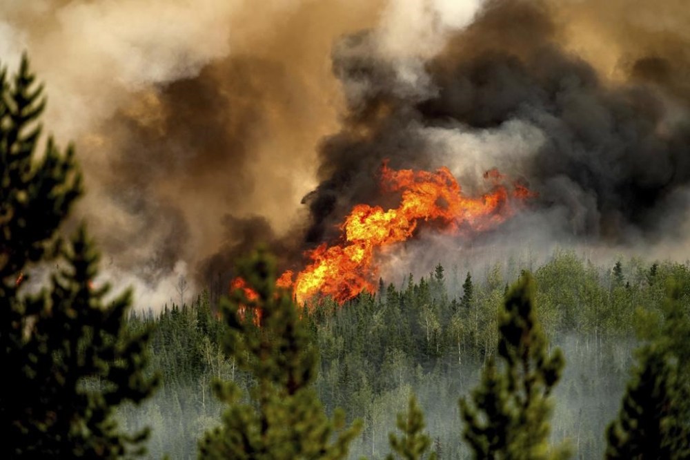Flames from the Donnie Creek wildfire burn along a ridge top north of Fort St. John, British Columbia, Canada, Sunday, July 2, 2023. A fundraiser has been launched to honour the memory of a firefighter killed while fighting British Columbia's largest wildfire last week.THE CANADIAN PRESS/AP, Noah Berger