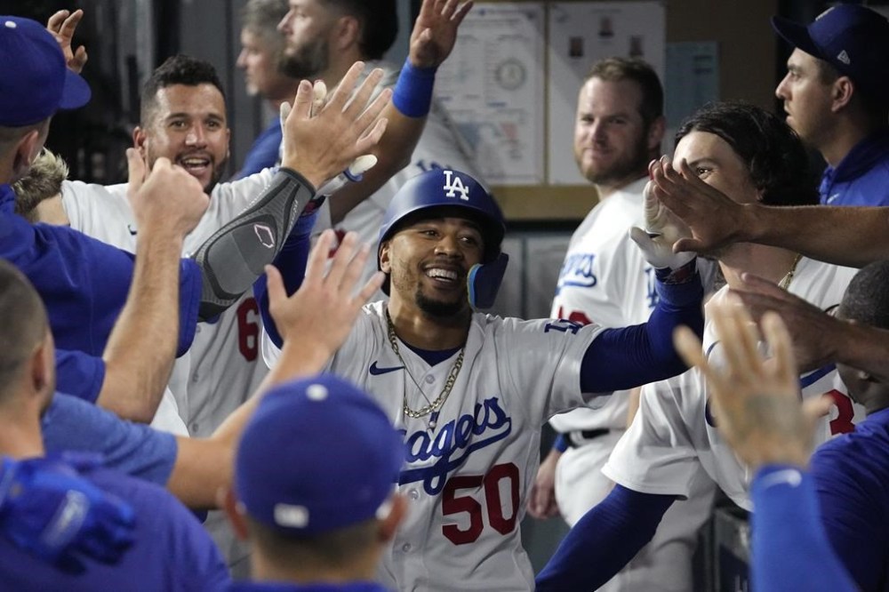 Los Angeles Dodgers' Mookie Betts is congratulated by teammates in the dugout after hitting a solo home run during the seventh inning of a baseball game against the Oakland Athletics Tuesday, Aug. 1, 2023, in Los Angeles. (AP Photo/Mark J. Terrill)
