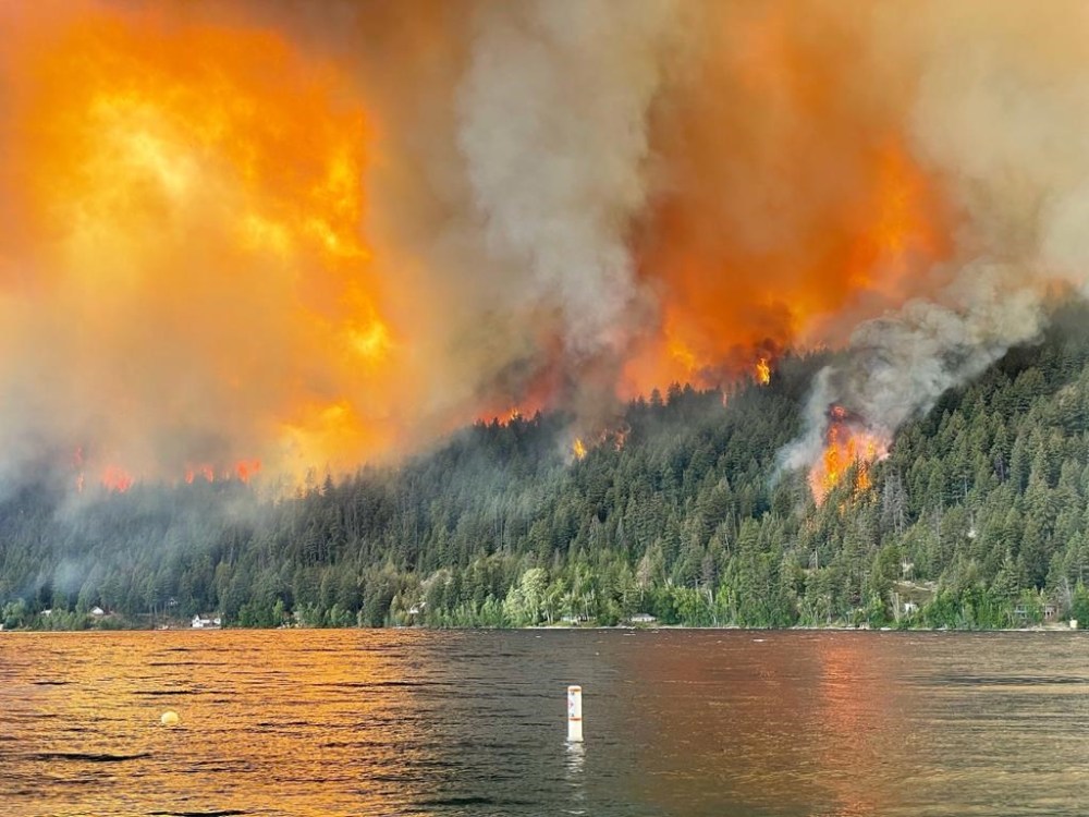 The Downton Lake wildfire near Gold Bridge B.C., burns toward the north shore of Gun Lake in this Tuesday, August 1, 2023 handout photo. THE CANADIAN PRESS/HO, Owen Rose *MANDATORY CREDIT*
