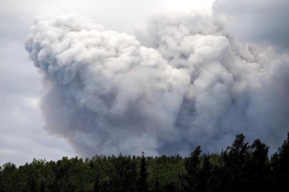 Smoke billows from the Donnie Creek wildfire burning north of Fort St. John, British Columbia, Canada, Sunday, July 2, 2023. Family, friends and colleagues are mourning a firefighter killed in northeastern British Columbia, the fourth fatality in one of the deadliest fire seasons in recent memory. THE CANADIAN PRESS/AP, Noah Berger
