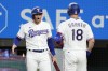 Texas Rangers' Brad Miller, left, and Mitch Garver (18) celebrate Garver's solo home run as he jogs back to the dugout in the fifth inning of a baseball game against the Chicago White Sox, Tuesday, Aug. 1, 2023, in Arlington, Texas. (AP Photo/Tony Gutierrez)