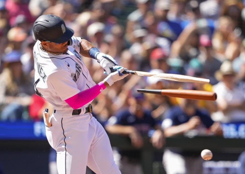 Seattle Mariners' Julio Rodriguez breaks his bat on an RBI single against the Boston Red Sox to score Tom Murphy during the seventh inning of a baseball game, Wednesday, Aug. 2, 2023, in Seattle. (AP Photo/Lindsey Wasson)