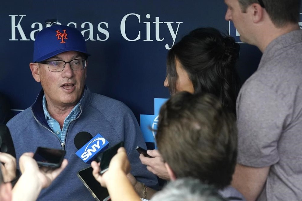 New York Mets owner Steve Cohen talks to the media in the dugout before a baseball game against the Kansas City Royals Wednesday, Aug. 2, 2023, in Kansas City, Mo. (AP Photo/Charlie Riedel)