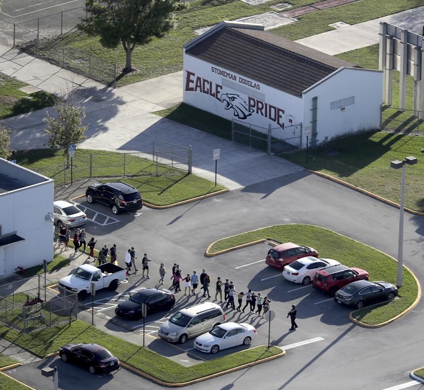 FILE - Students are evacuated by police from Marjory Stoneman Douglas High School, Wednesday, Feb. 14, 2018, in Parkland, Fla., after a shooter opened fire on the campus. A reenactment of the 2018 massacre that left 17 dead, 17 wounded and hundreds emotionally traumatized, is scheduled to be conducted Friday, Aug. 4, 2023, as part of lawsuits filed by the victims