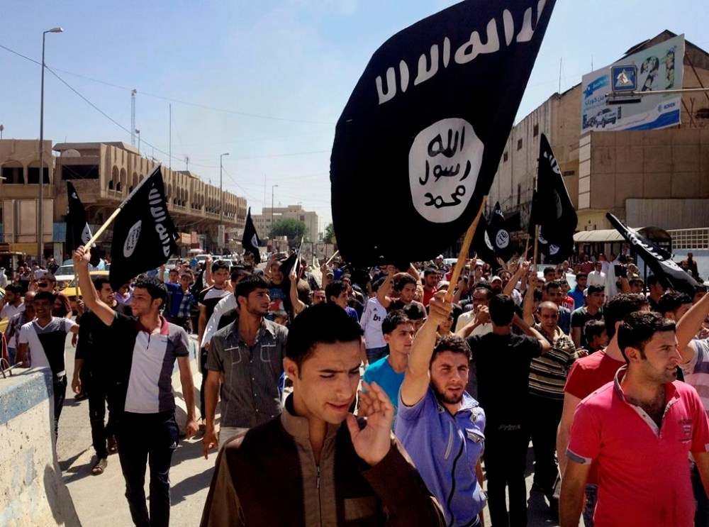 FILE - Demonstrators chant pro-Islamic State group slogans as they carry the group's flags in front of the provincial government headquarters in Mosul, Iraq, June 16, 2014. The Islamic State group announced Thursday the death of its little known leader Abu al-Hussein al-Husseini al-Qurayshi who had been heading the extremist organization since November. (AP Photo, File)