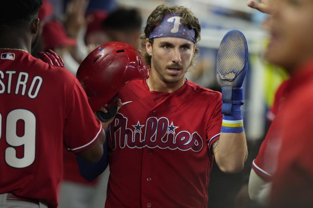 Philadelphia Phillies' Bryson Stott is greeted by the team after scoring a run during the seventh inning of a baseball game, Thursday, Aug. 3, 2023, in Miami. The Phillies defeated the Marlins 4-2. (AP Photo/Marta Lavandier)