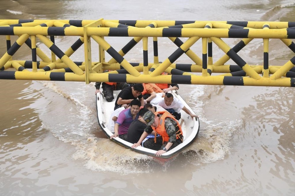 In this photo released by Xinhua News Agency, residents are evacuated from flooded areas in Zhuozhou in northern China's Hebei Province on Wednesday, Aug. 2, 2023. A highway bridge in northern China collapsed due to flash floods triggered by heavy rains, and two cars fell into the river, state media reported Thursday, as parts of China are experiencing the worst floods in decades. (Mu Yu/Xinhua via AP)